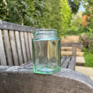 Empty honey jar sitting on a bench